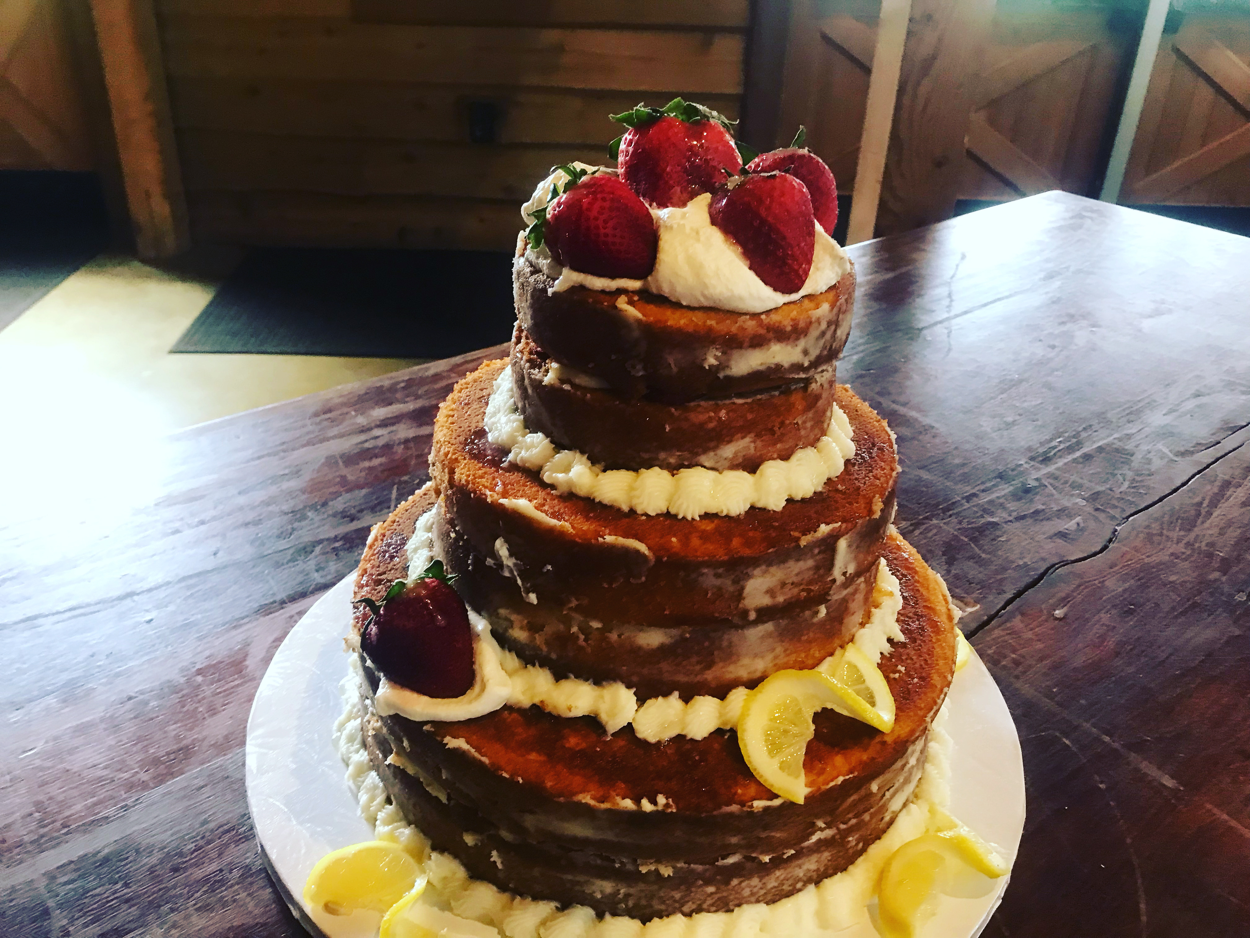 Naked lemon cake with strawberries and whipped cream