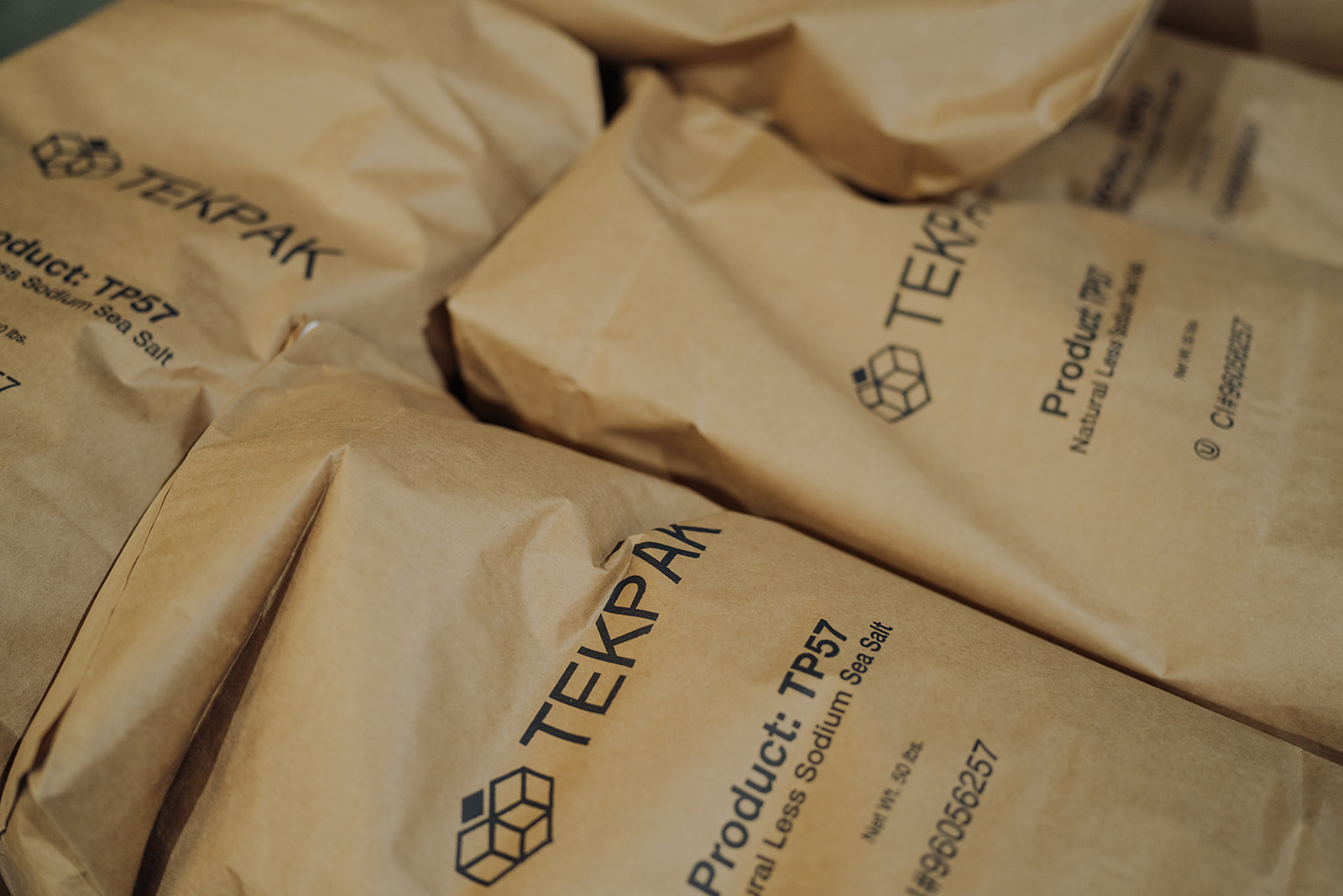 Multiple TEKPAK-branded 50lb sea salt bags stacked at the Marion, AL facility